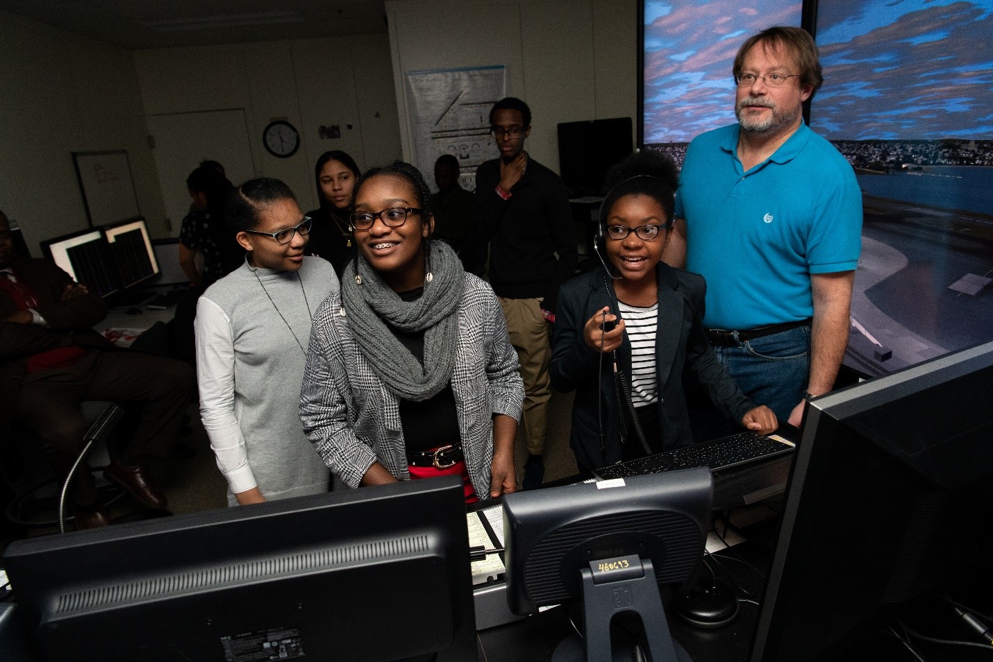 Three students direct virtual planes down the runway with the help of Brad Crowe. Photo: Nicole Fandel