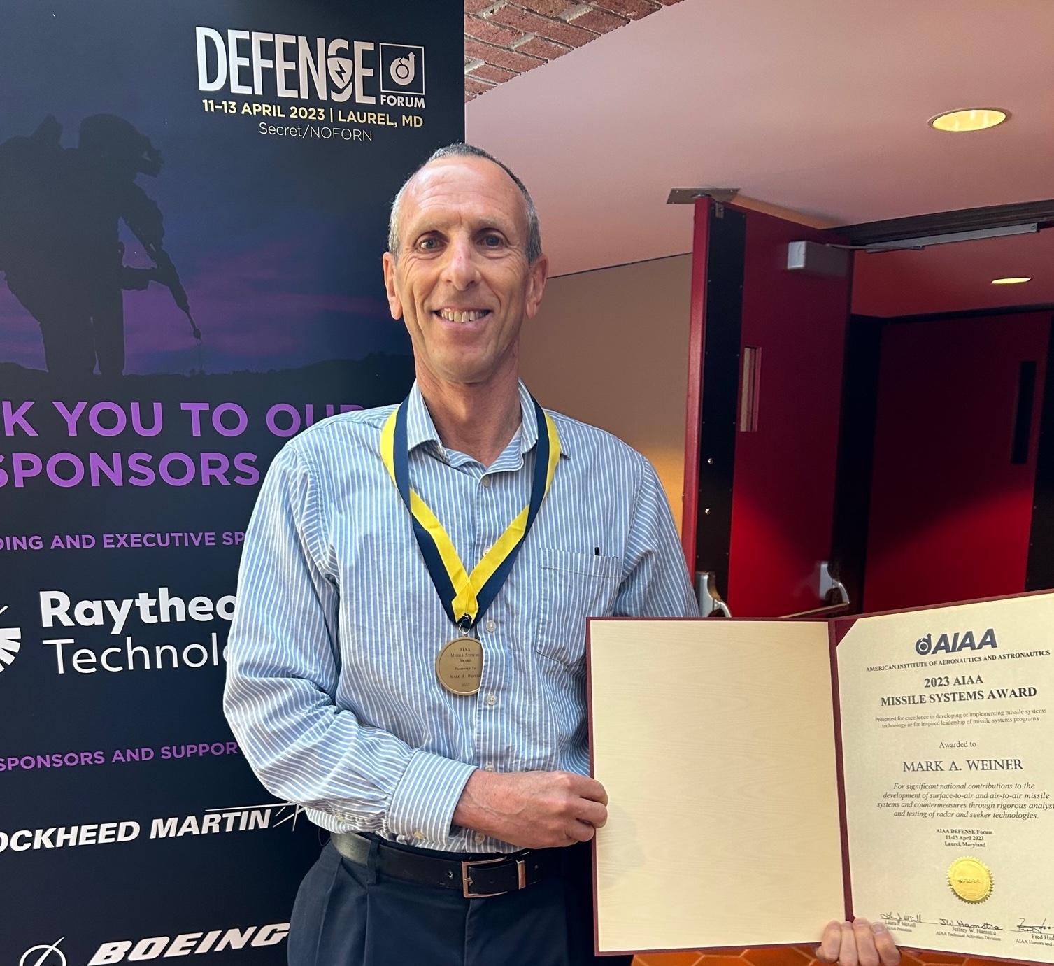 A photo of a man holding an award he received.