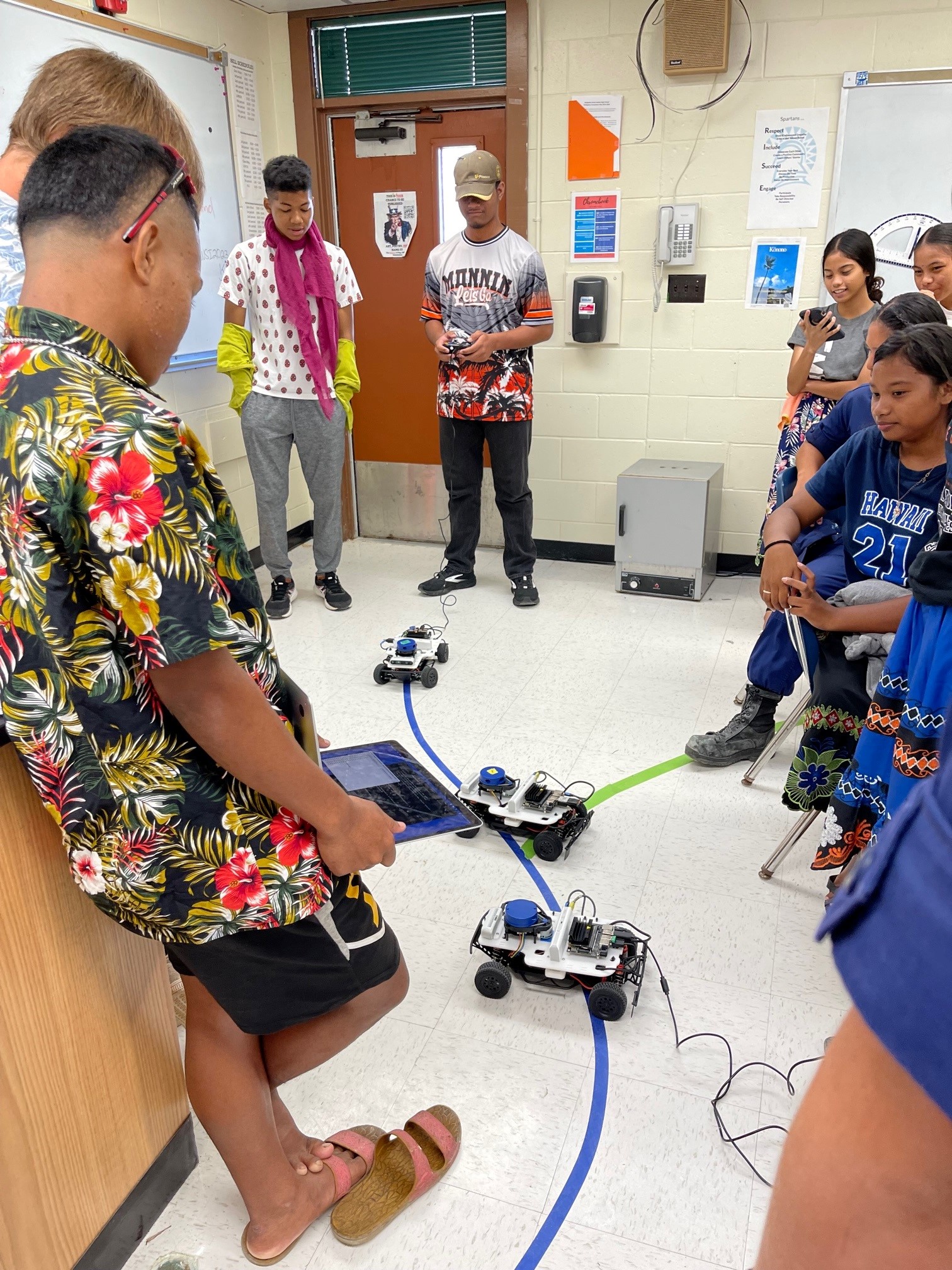 A group of students program and test miniature racecars.