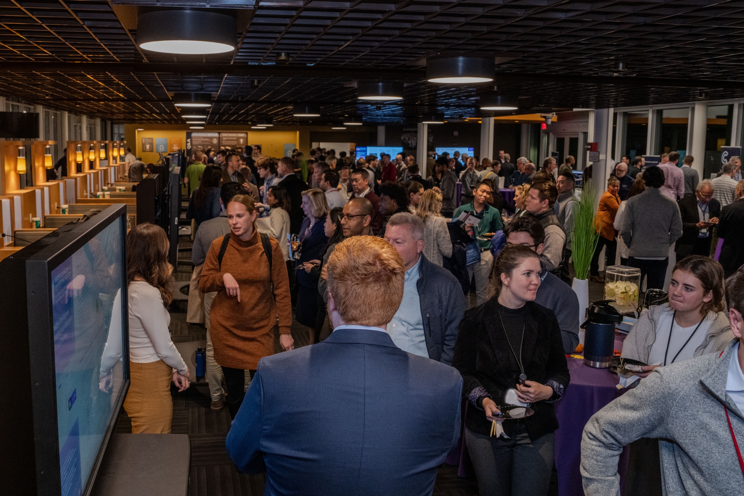 a cafeteria is filled with people talking and mingling. 