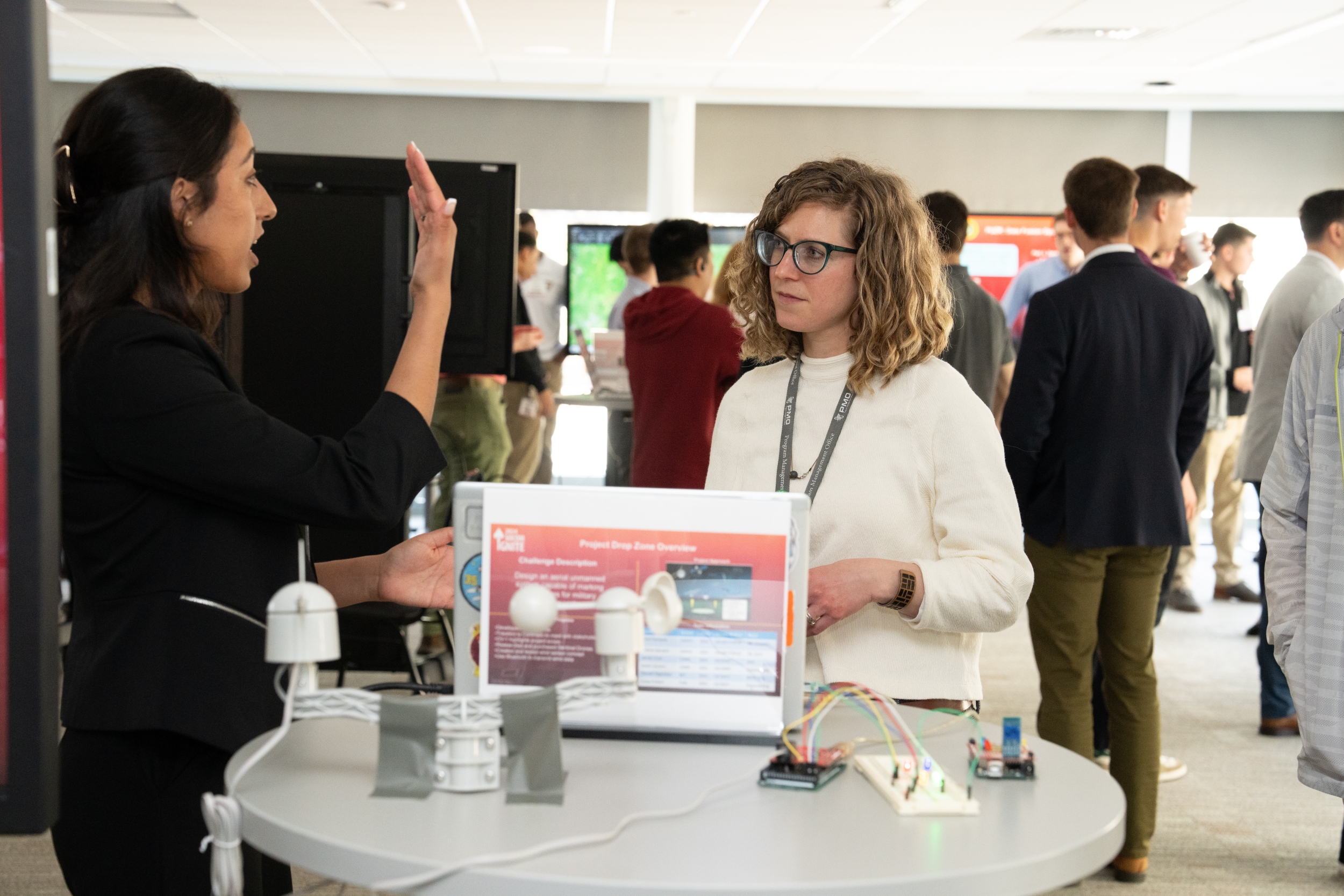 A cadet discusses her technology with a Laboratory staff member at the technology expo.