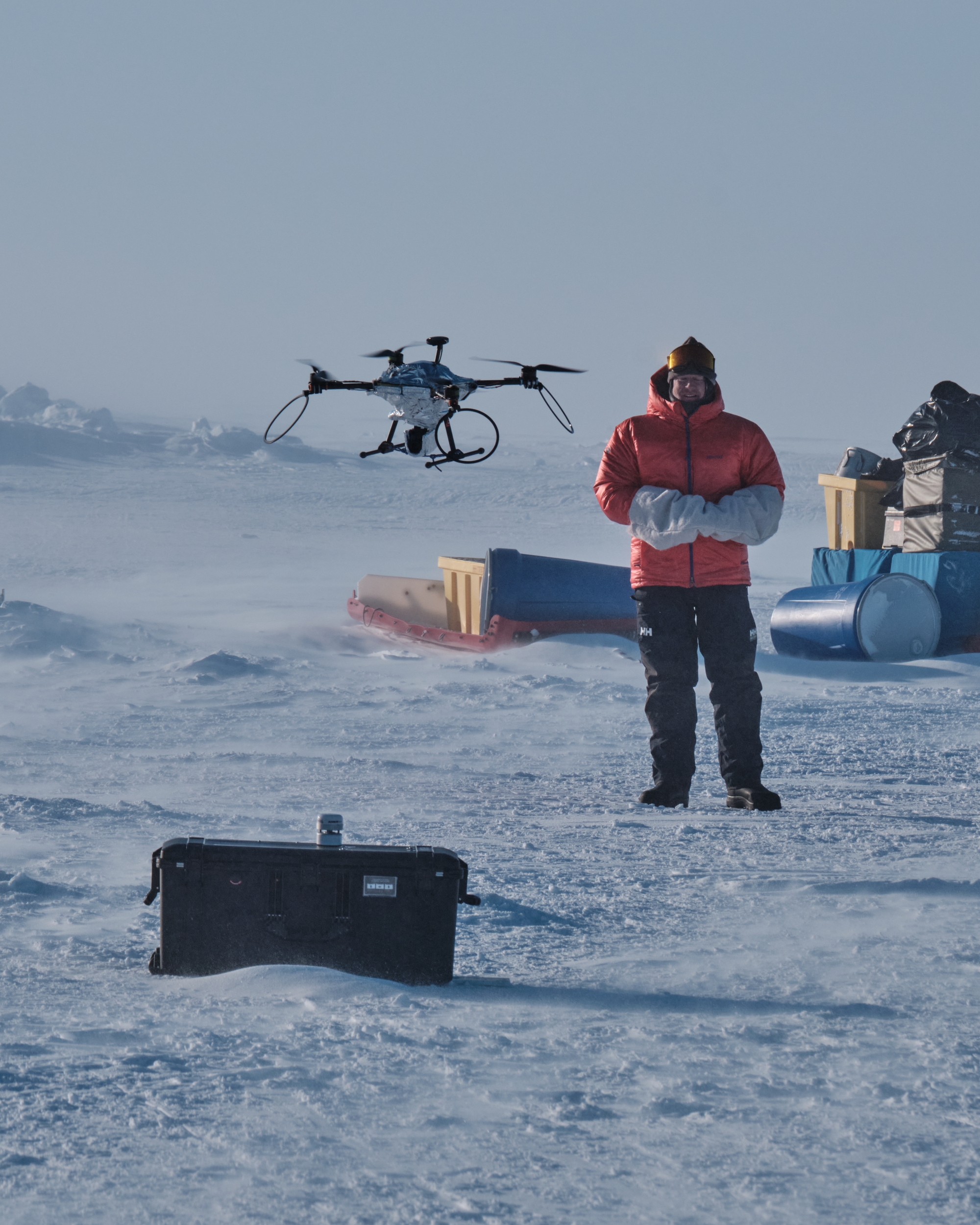 A person flies a drone near a sensor node in the Arctic. 