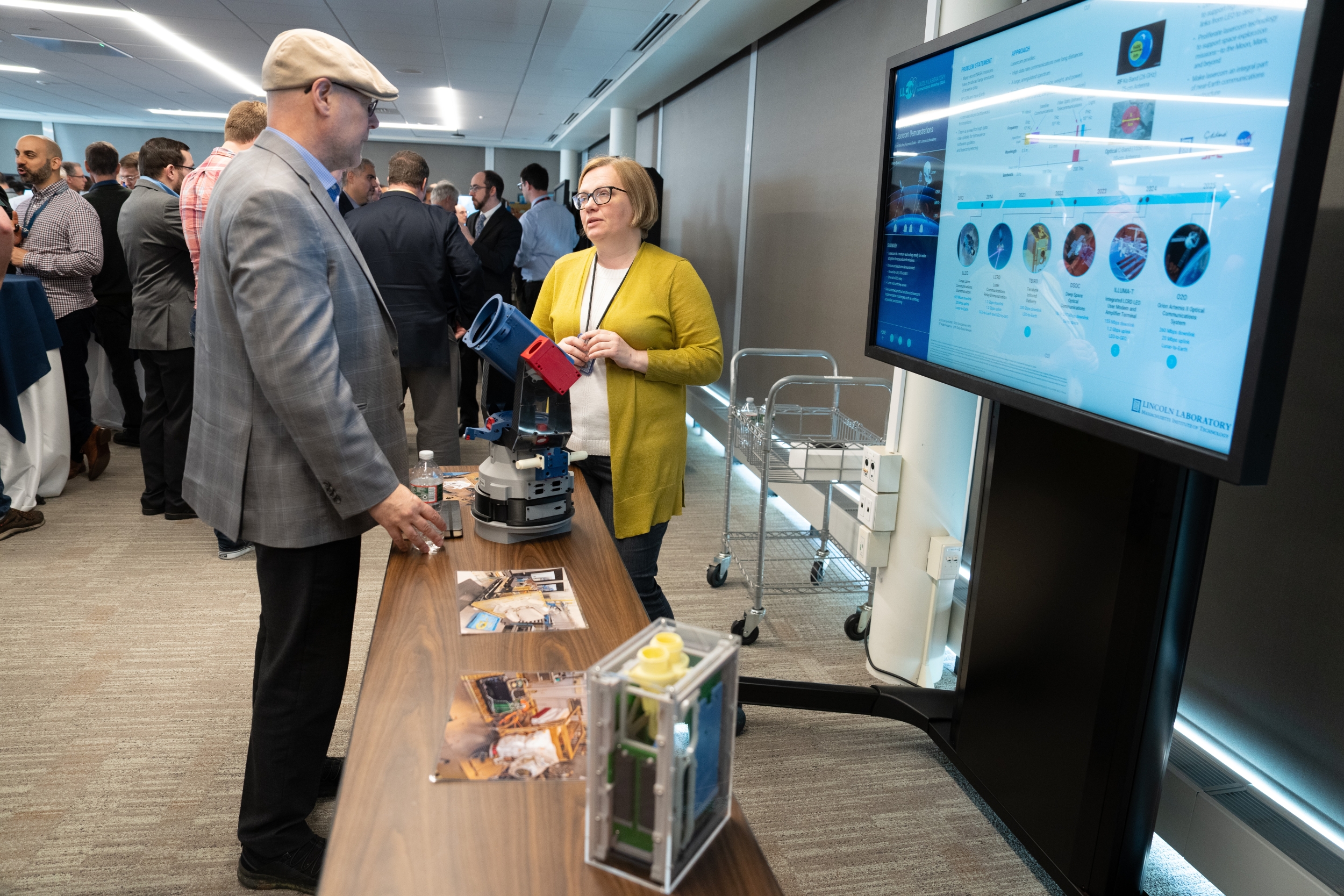 Two people talk at a poster presentation session.