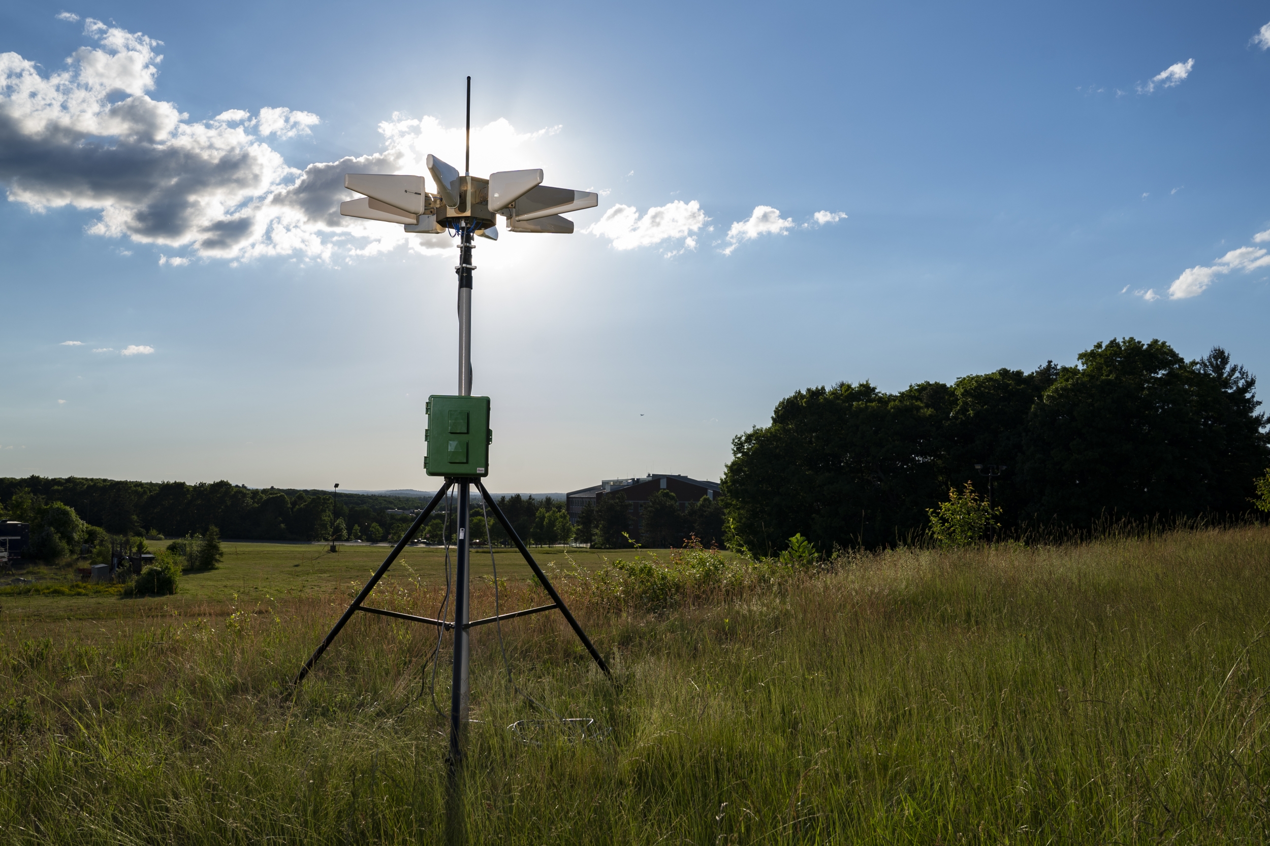 a sensor/instrument on a tripod, set up in a field.