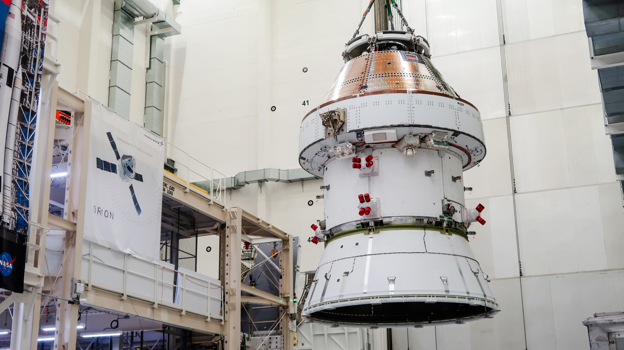 A spacecraft is lifted into a vacuum chamber for testing.