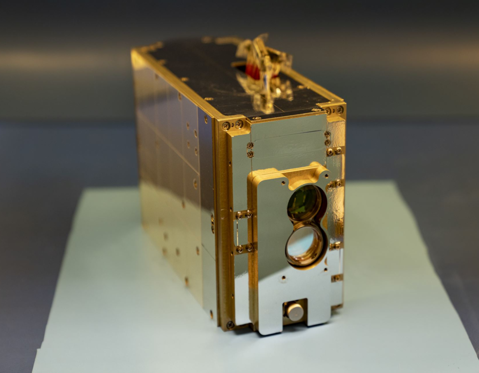 A photo of a small laser communications payload, about the size of a tissue box.