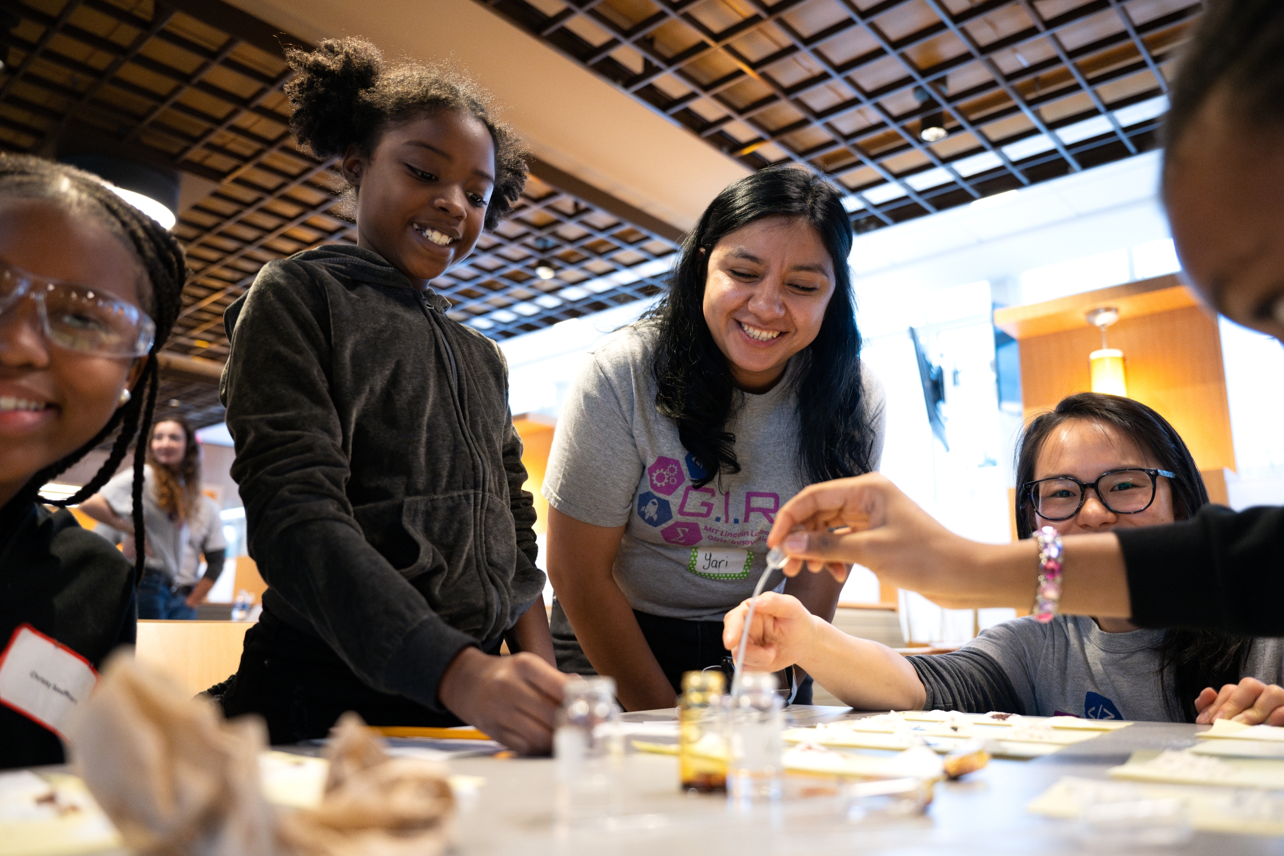 A woman helps girls identify physical changes to food items undergoing chemical reactions.