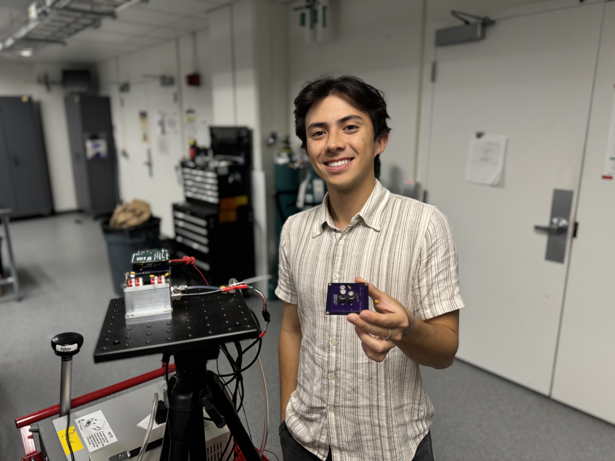 Intern Mati Ng holds a small sensor. 