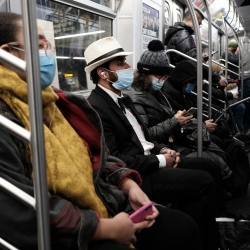 An image of riders on a subway train