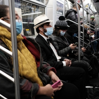 An image of riders on a subway train