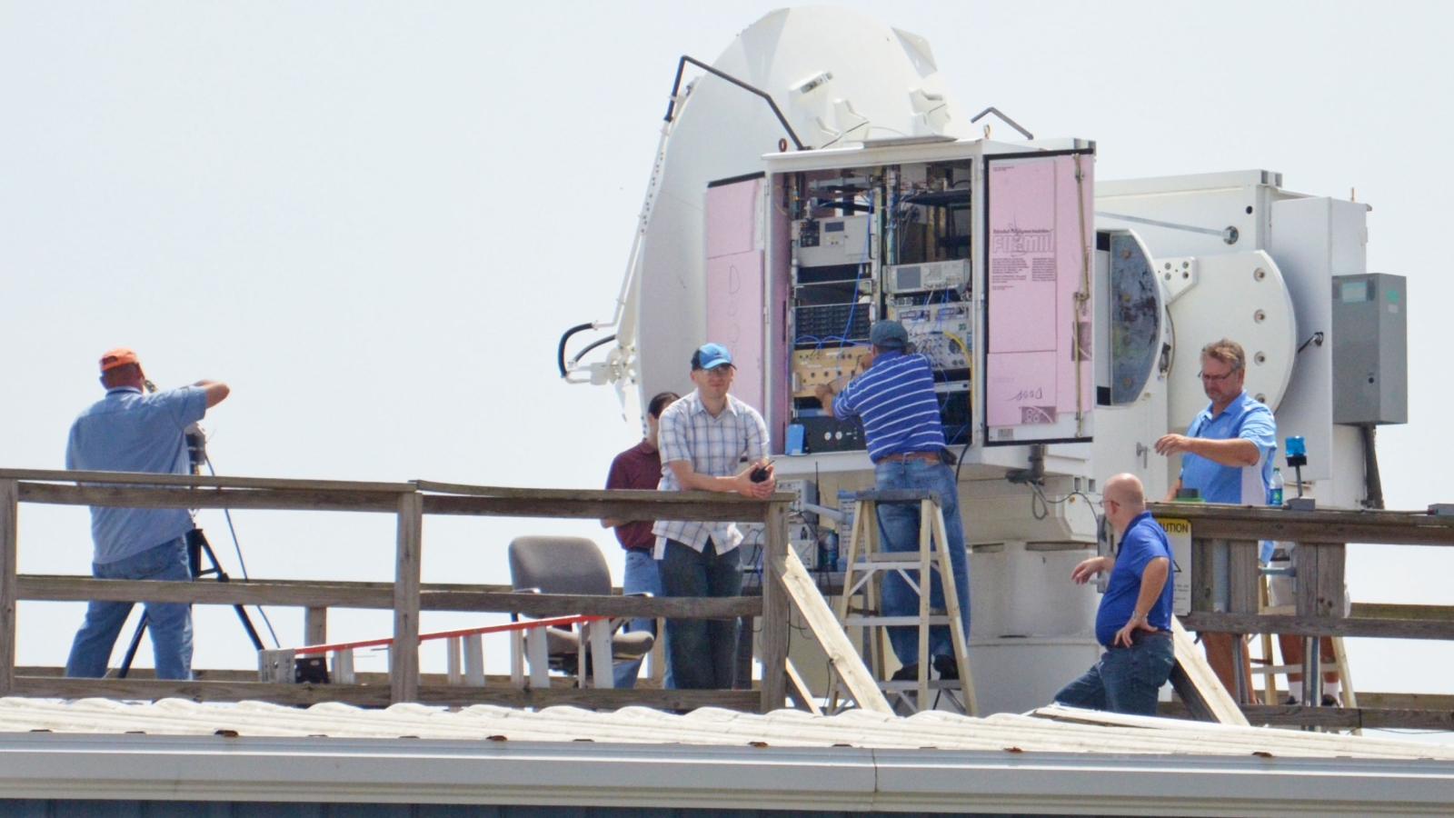 Six people work on radars at a naval air station. 