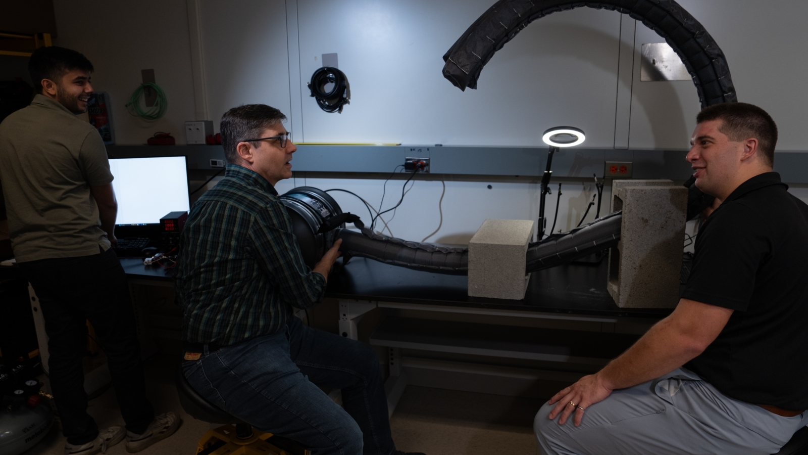 Three project team members test the robot's flexibility in an indoor laboratory setting. 